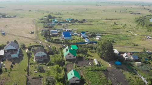 View From Above at a Small Village in Russia. Small Houses and Fields Around.