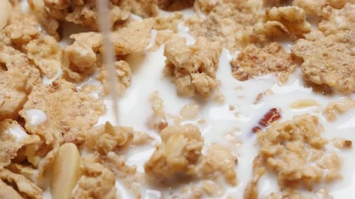 Milk Poured Over Breakfast Cereal in White Bowl