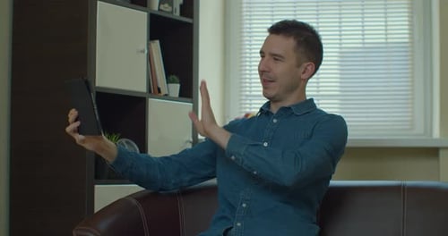 Young Man Uses Tablet at Home