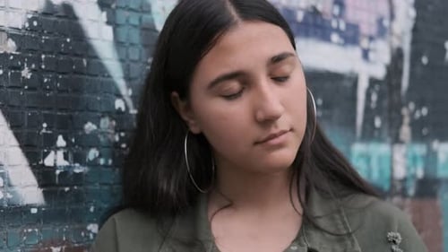 Cheeky Brunette Girl Turns and Slaps Her Hand on the Wall with Graffiti