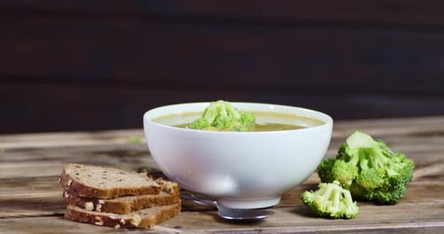 Broccoli Soup with Bread on Wood Table