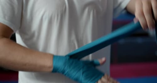 Boxing, Training Day, Boxing Gym, a Male Boxer Puts a Special Bandage on His Hands Before the Fight