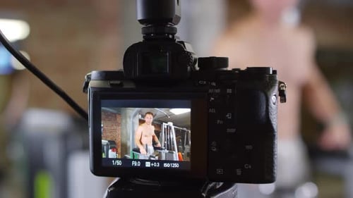 Shirtless Bodybuilder Recording Video of Gym Workout