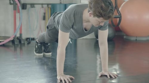 Asian young man doing push up with strength and power for bodyweight in the gym.