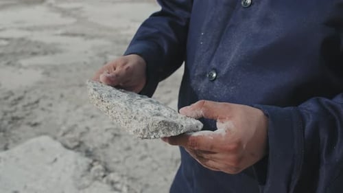 Unerkennbare Person hält ein Stück Granit in der Hand