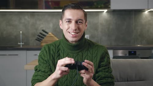 Excited Young Adult Playing Video Games at Home