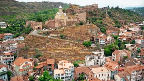 Aerial drone view of Tbilisi, Georgia at cloudy weather. St. Nicholas Church located on a cliff, bui