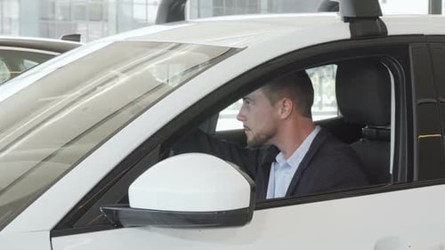 Handsome Man Sitting in New White Car