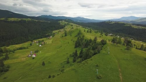 Scenic Aerial View of Rolling Green Hills and Mountains