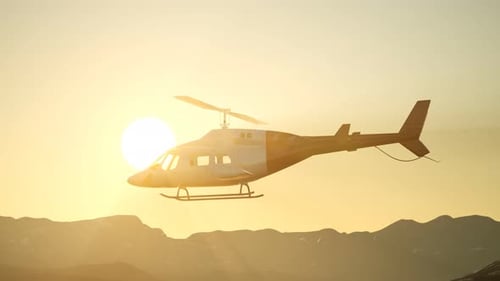 Modern Helicopter Flying Over Mountains at Golden Sunset