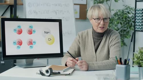 Online School Employee Teaching Chemistry Class Pointing at Computer Monitor and Talking