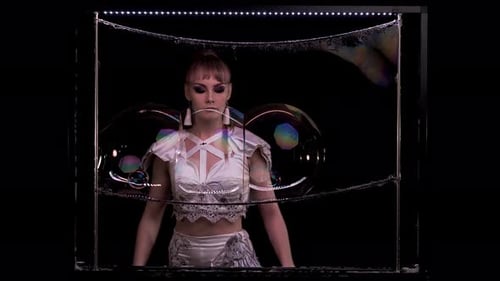 Woman Creating Giant Soap Bubbles in Luminous Frame