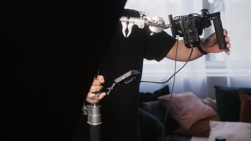 Videographer Adjusting Camera and Equipment in Studio
