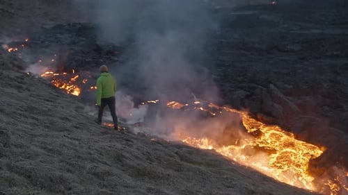 Man Walking Alongside Lava Flow From Erupting Fagradalsfjall Volcano