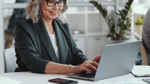 Portrait of Positive Senior Businesswoman at Work in Office