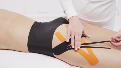 Applying Medical Tape to Woman's Thigh