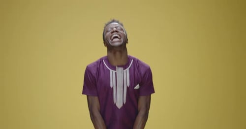 Young Adult Dances in Front of Yellow Background