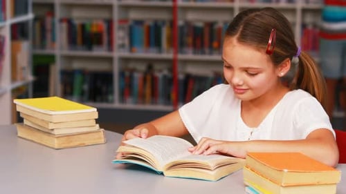 Schoolgirl reading book in library