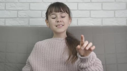 Girl Speaking and Waving at Camera Indoors