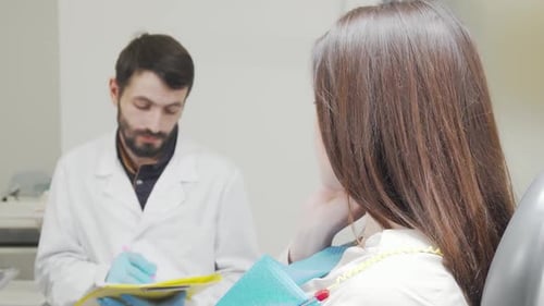 Woman with Toothache Looking to the Camera Sitting in Dental Chair