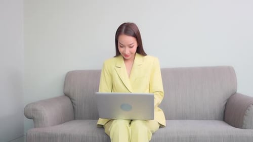 Young Woman Works on Laptop, Celebrates Success
