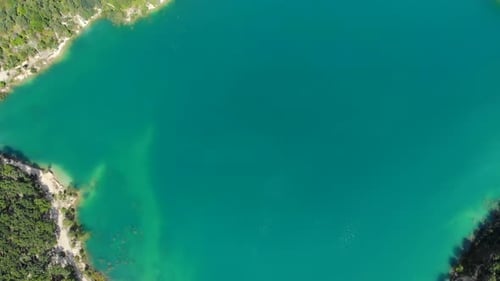 Aerial View of a Blue Lake Surrounded By Forest.