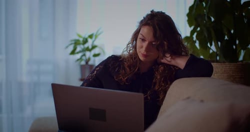 Woman Working on Laptop on Couch at Home
