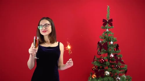 Woman Celebrating Christmas with Champagne and Sparkler