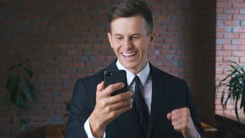 Excited Man Celebrates Good News on Phone