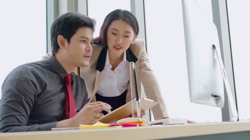 Two Business People Talk Project Strategy at Office