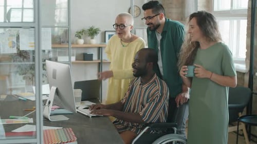 Afro-Mann im Rollstuhl arbeitet mit Geschäftsteam im Büro