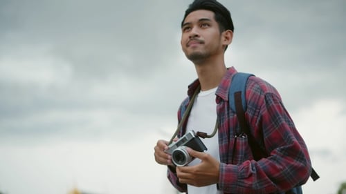 Blogueiro asiático feliz curtindo viagens de lazer e estilo de vida.