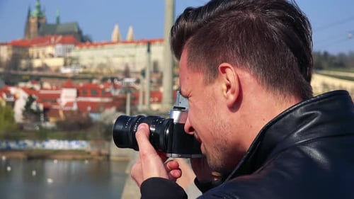 Man Taking Photos of Cityscape on Bridge