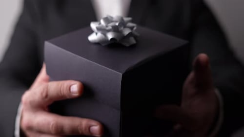 Man Holding a Gift Box with Silver Ribbon