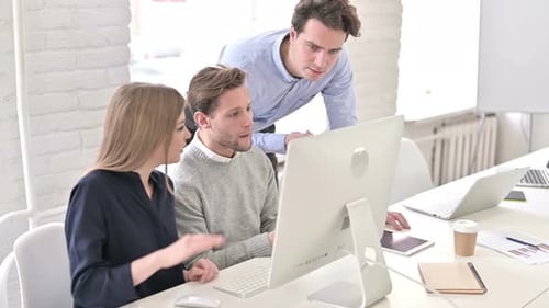Attractive Startup Team Discussing and Working on Desktop