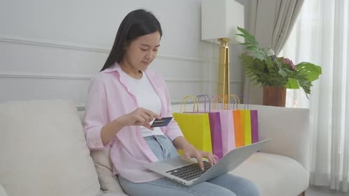 Woman Shopping Online with Credit Card on Laptop