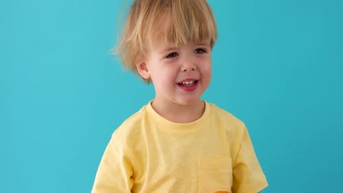 Happy Child Playing with Oranges in Studio