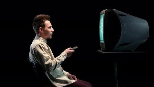 Man Sits Watching Old TV with Static