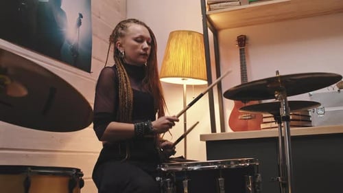 Woman with Braids Playing Drums in Home Studio