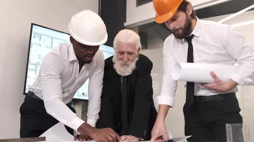 Architects Reviewing Plans Together in Modern Office