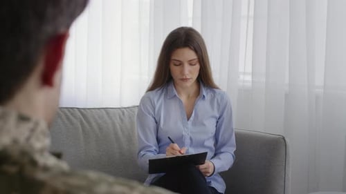 Woman Taking Notes During Therapy Session