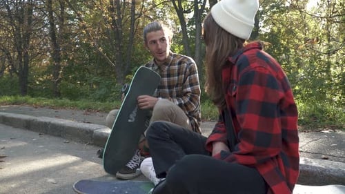Friends Chatting in Urban Park with Skateboards