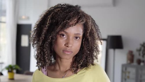 Woman with Curly Hair Looking at Camera Indoors