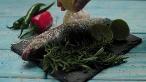 Lemon Squeezed over Fresh Whole Fish Close Up