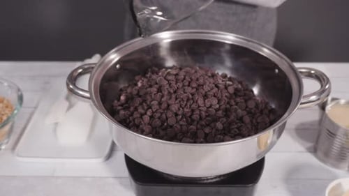 Step by step. Melting chocolate chips in the cooking pot to make macadamia nut fudge.