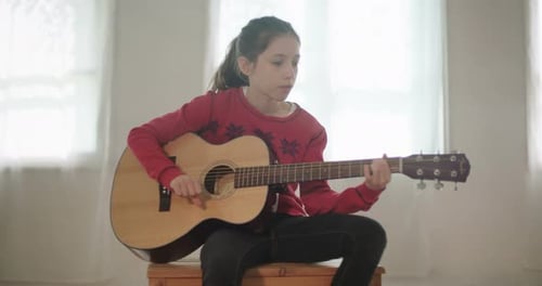 Girl Plays Acoustic Guitar in Bright Room