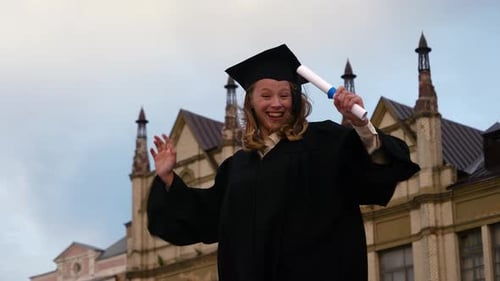 Happy Graduate Student Holding a Diploma Smiling To Camera.