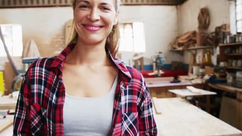 Smiling Woman in Workshop with Tool Belt