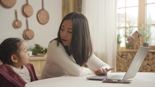 Woman and Child Using Laptop at Home