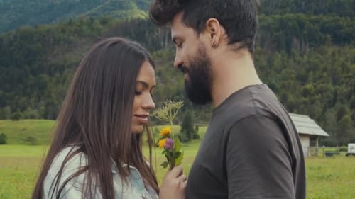 Romantic happy couple with flowers in countryside